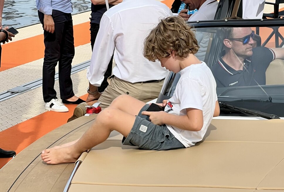 EGEN VERDEN: En liten gutt på dekket av en båt i Cannes er mer oppslukt av en iPhone enn av livsstilen båtene forsøker å lokke med.