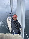 Person tar selfiebilde på dekk på en seilbåt ute på åpent hav.