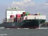 Stort containerskip med stablede containere seiler på vannet.